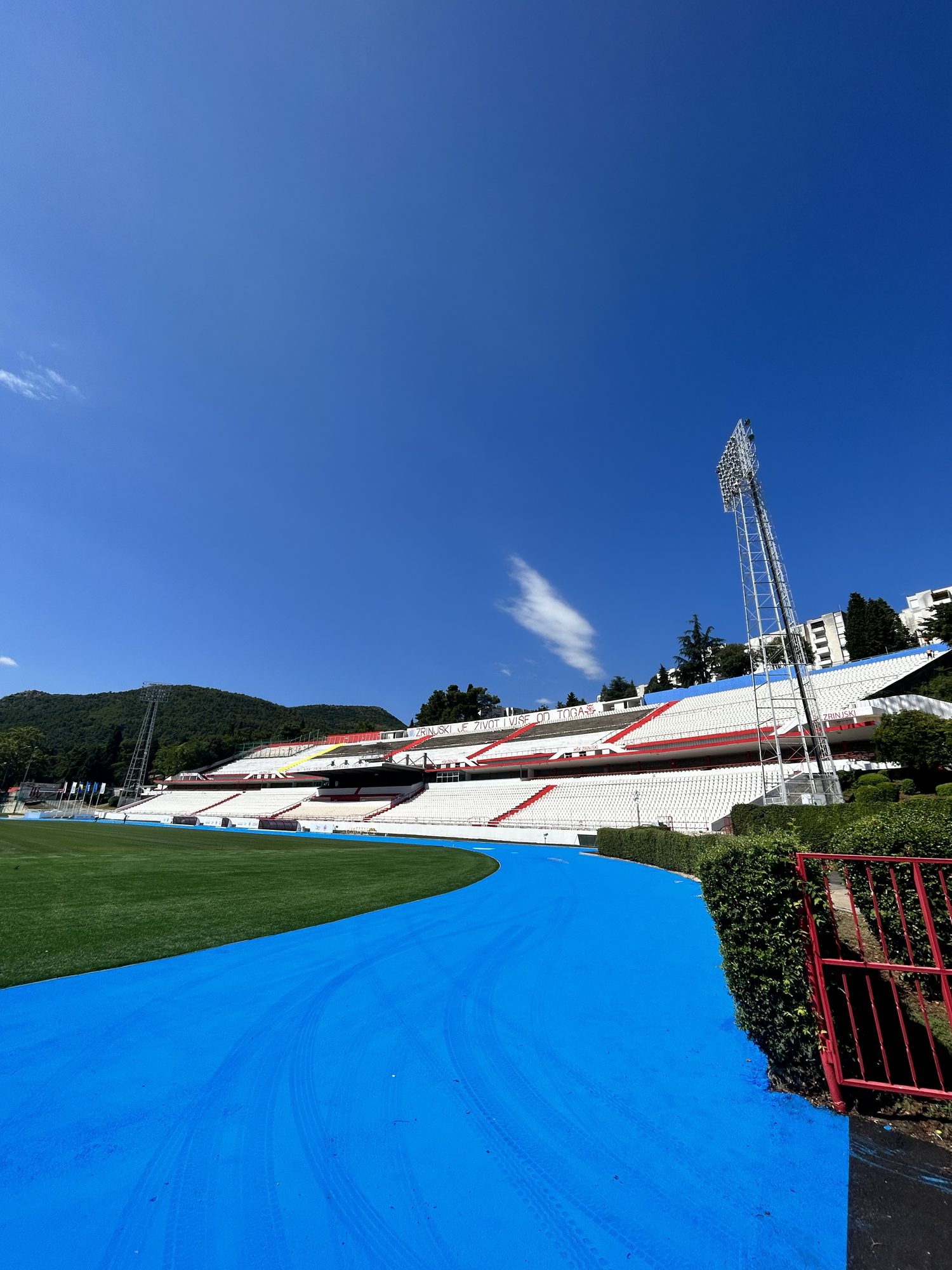 HŠK Zrinjski Mostar stadium — blue track, Dinaric Alps